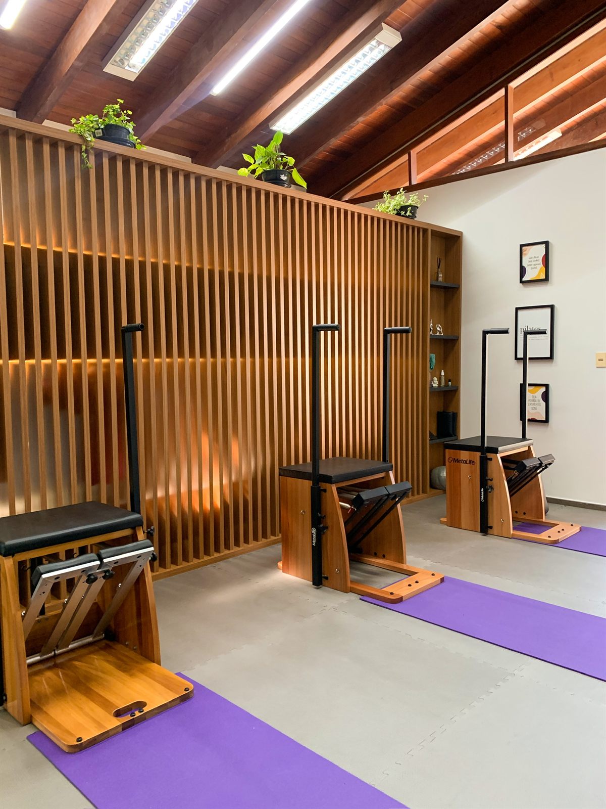 Interior do estúdio Kantamá Pilates com aparelhos e acabamento em madeira